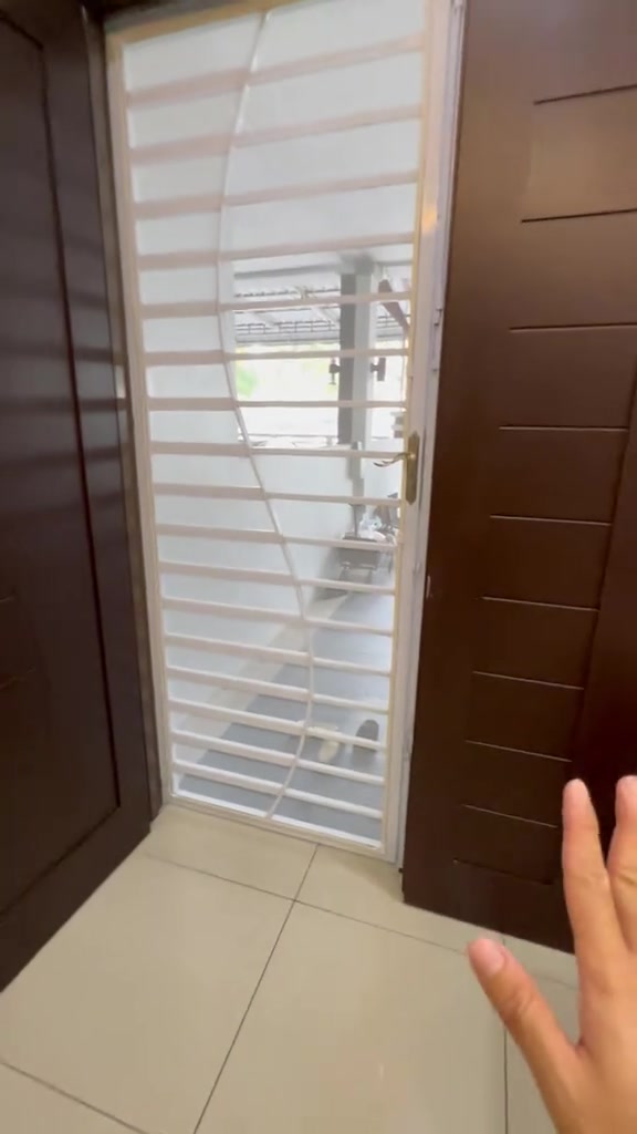 Skrin jaring nyamuk putih dipasang pada pintu belakang di antara dua pintu kayu coklat, dengan tangan menghala dari tepi