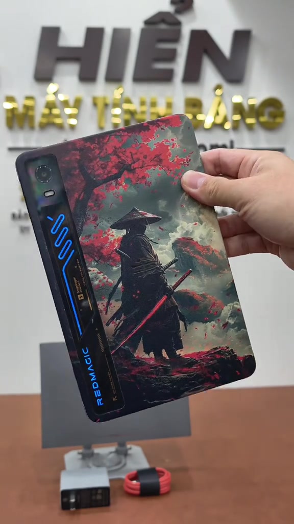 Mặt lưng máy tính bảng REDMAGIC Pad với dải đèn RGB và logo REDMAGIC, cầm trên tay tại cửa hàng máy tính bảng