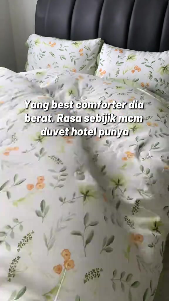 Comforter putih bercorak bunga kecil terbentang atas katil kepala katil hitam bersama dua bantal sepadan