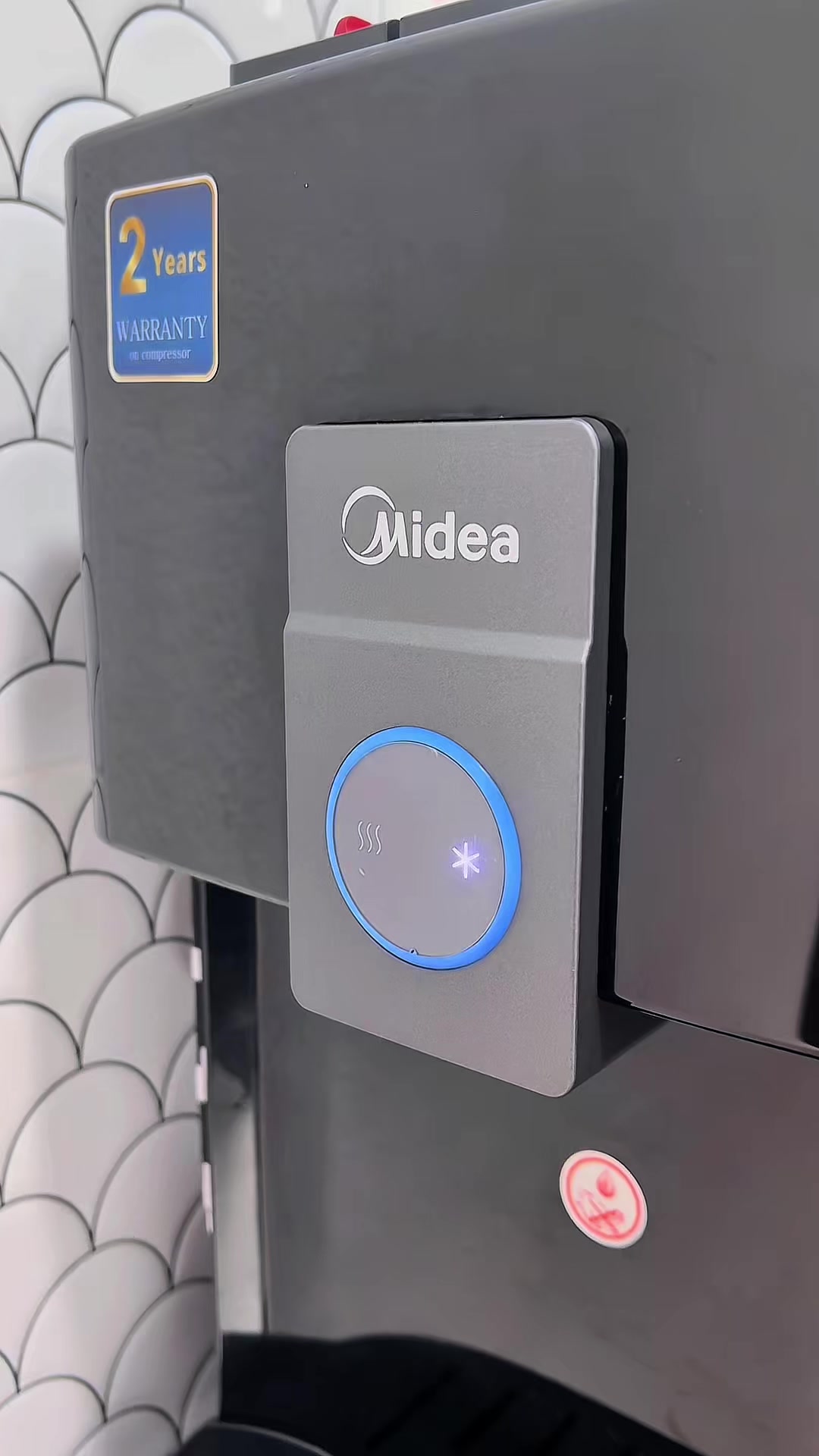 Panel dispenser Midea dengan butang air panas dan sejuk serta sticker warranty 2 tahun pada compressor