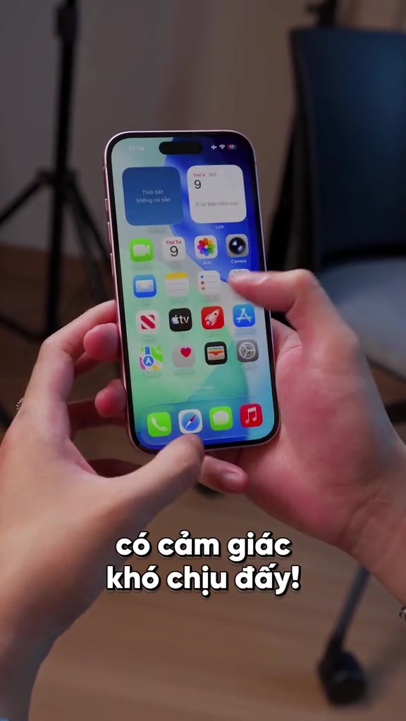 Mặt trước iPhone 15 màu hồng hiện màn hình chính, cầm bằng hai tay