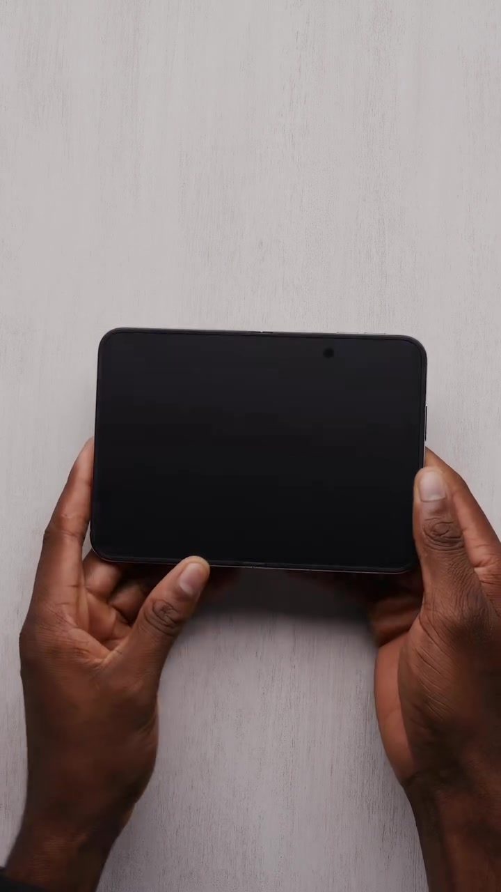 iPhone Duo terbuka dengan paparan dalam keadaan mati, kamera bawah paparan kelihatan sebagai titik kecil penjuru kanan