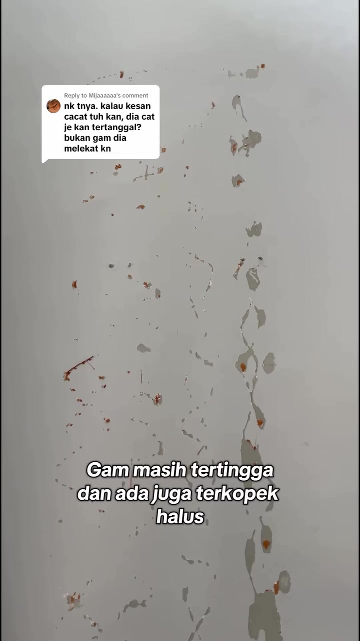 Dinding putih dengan sisa gam dan kesan cat terkopek halus selepas panel ditanggalkan