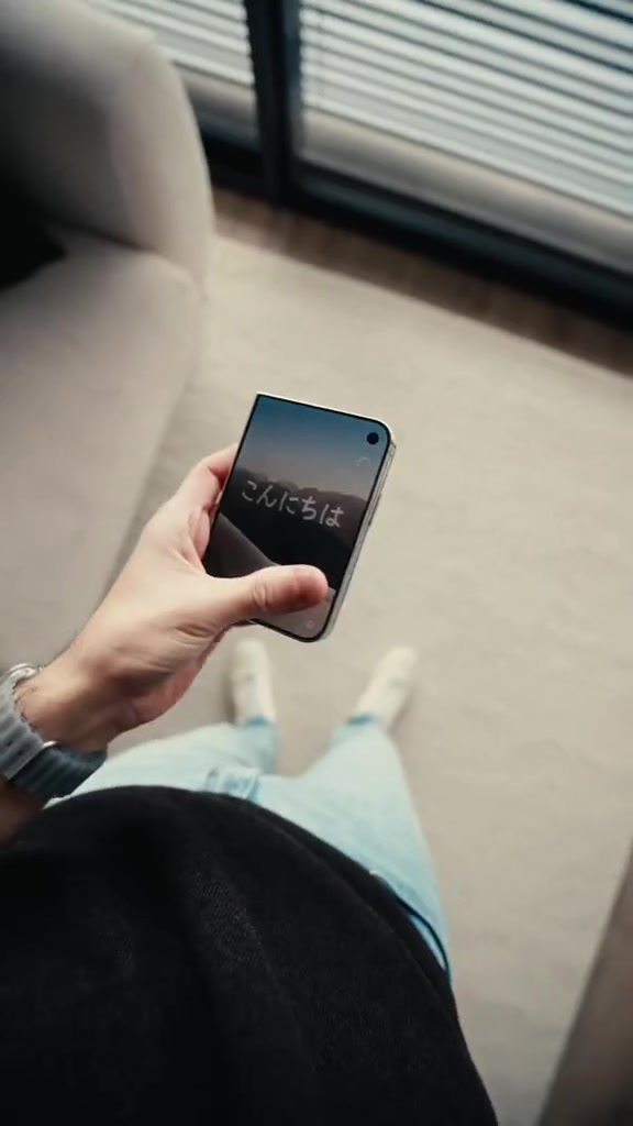 iPhone Duo keadaan tertutup dipegang satu tangan dengan paparan luar hidup