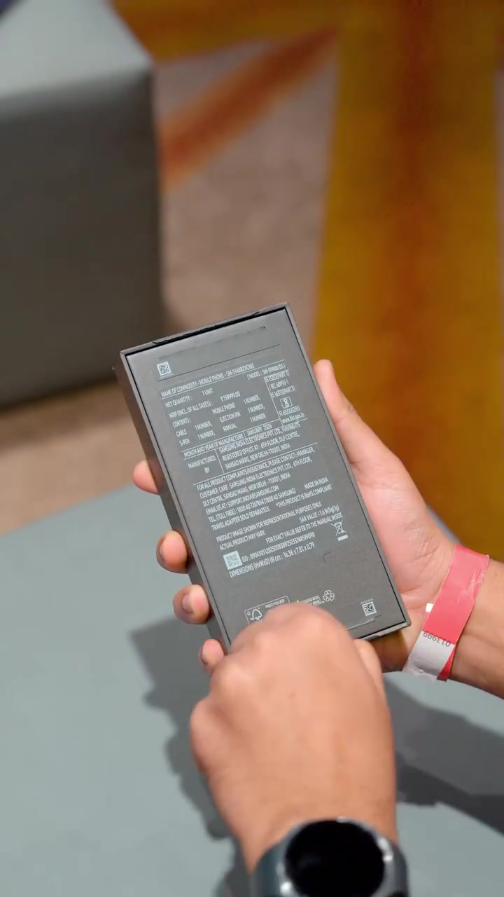 Belakang kotak Galaxy S26 Ultra dipegang dua tangan menunjukkan label maklumat komoditi dan tempoh waranti