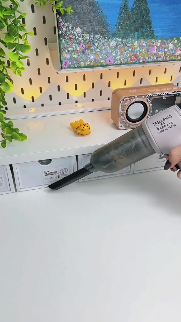 Thân máy hút bụi cầm tay Tamashio màu xám gắn đầu khe đặt trên bàn trắng, nhìn rõ logo và dòng chữ in trên thân máy