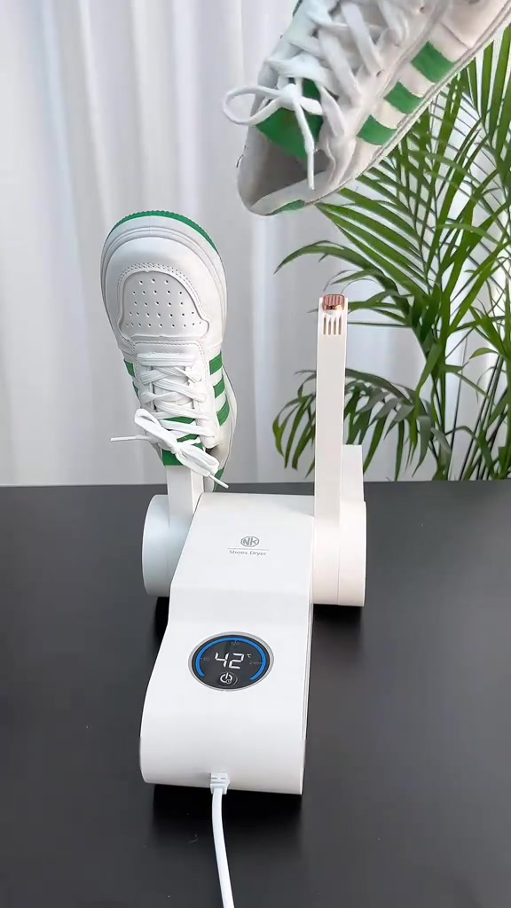 Unit pengering kasut berlengan warna putih dengan sepasang sneaker atasnya, display tunjuk 42°C