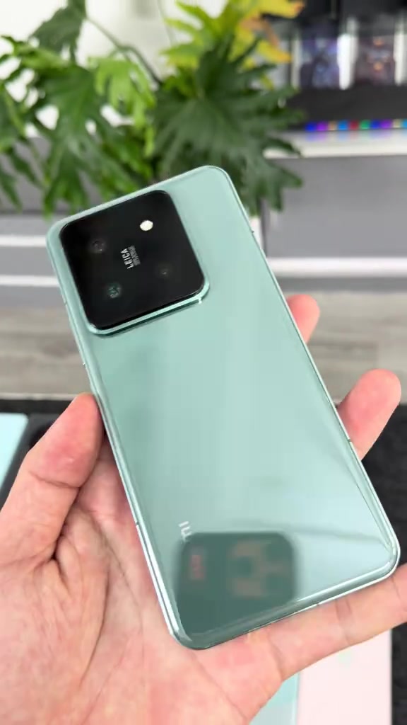 Mặt lưng kính màu xanh nhạt của Xiaomi 14 Pro với cụm camera Leica viền răng cưa, cầm trên tay