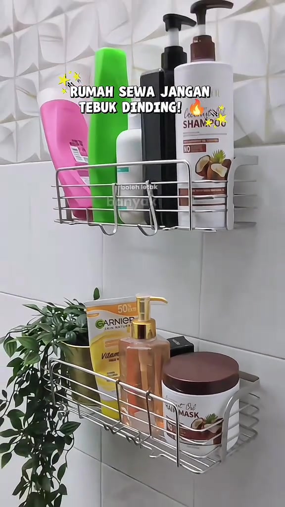 Dua rak wayar stainless melekat pada dinding jubin putih, penuh botol mandian