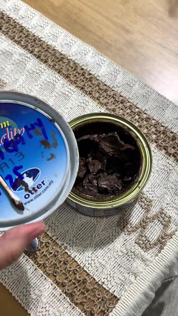Tin wax kayu coklat terbuka dengan cotton bud di atas runner meja berjalin