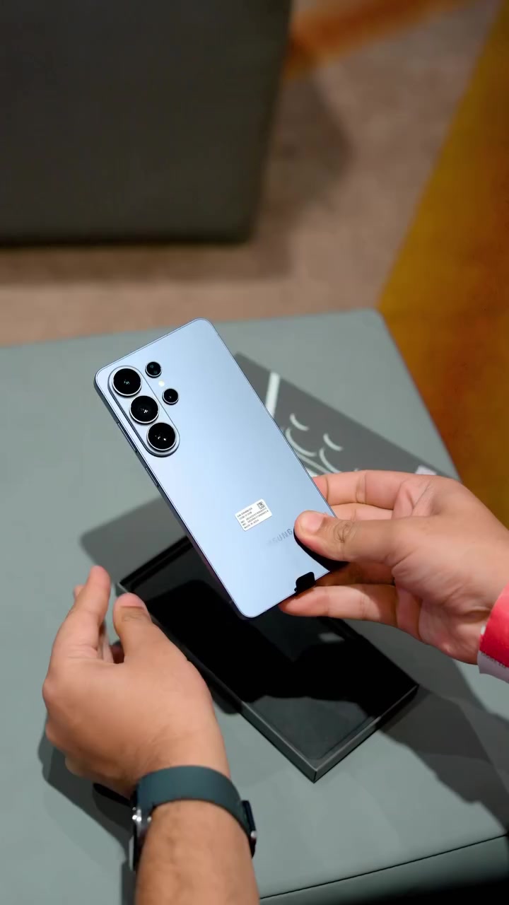 Galaxy S26 Ultra warna biru muda dipegang dua tangan di atas kotak asalnya