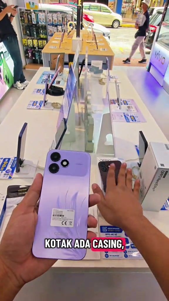 Kaunter kedai dengan unit OPPO A6c warna ungu dan brown beserta kotak jualan di sebelah