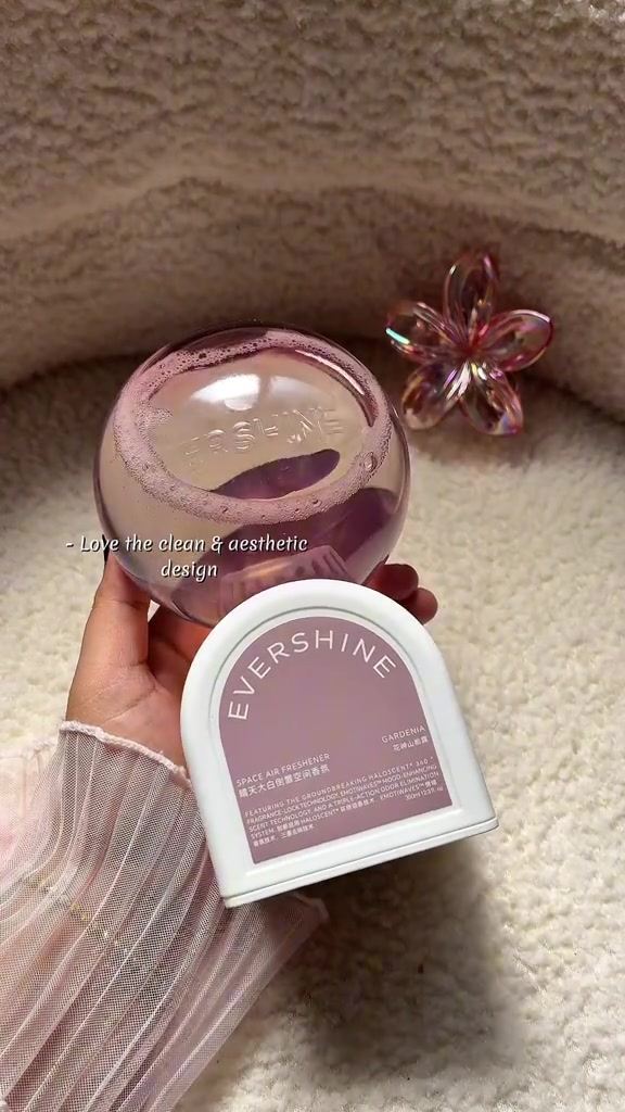 Tangan memegang pewangi ruang Evershine bau gardenia berbentuk bola merah jambu dengan tapak putih