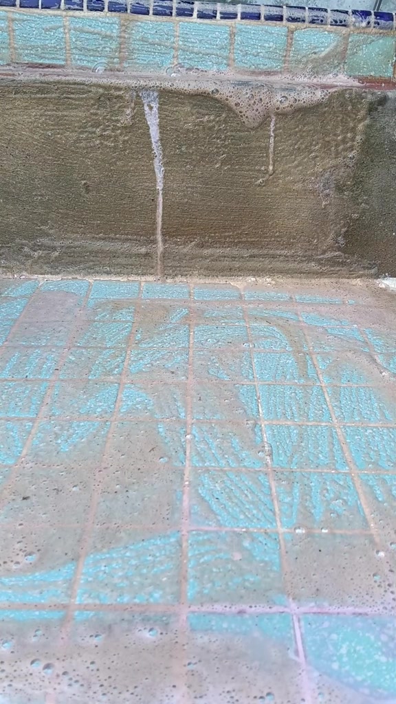 Lantai jubin turquoise selepas dibilas, celah nat nampak lebih cerah dengan sisa buih