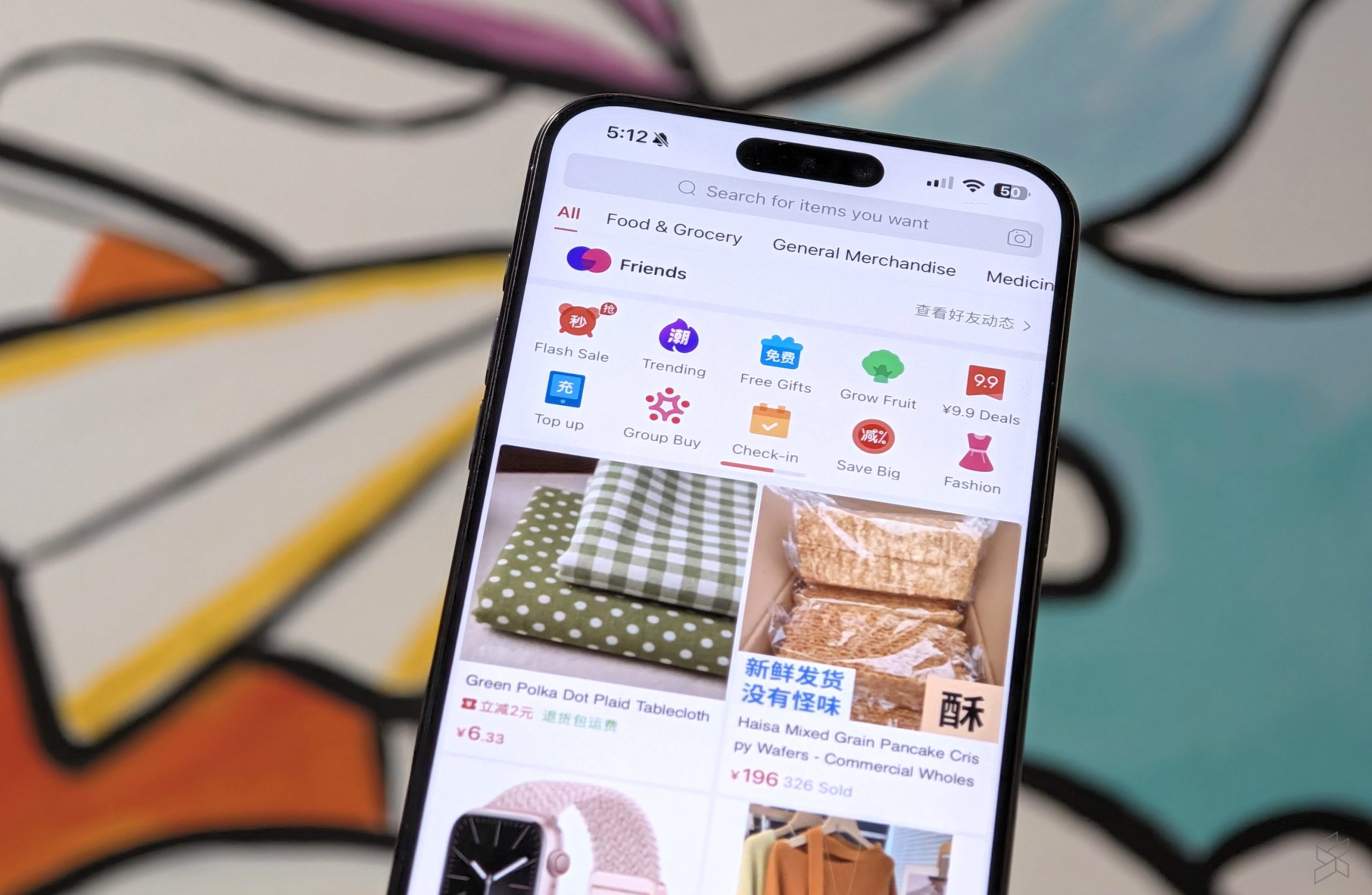 Telefon pintar memaparkan halaman utama aplikasi Pinduoduo versi bahasa Inggeris dengan kategori Flash Sale, Trending dan Free Gifts