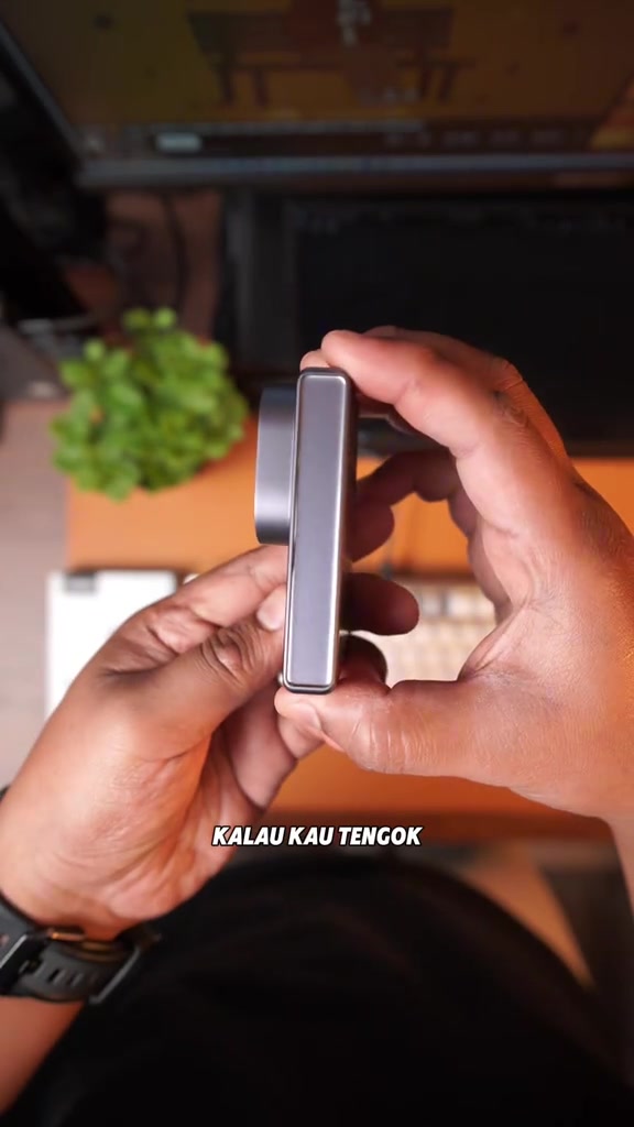Profil sisi pengecas UGREEN Nexode Air yang sangat nipis dipegang dengan dua tangan