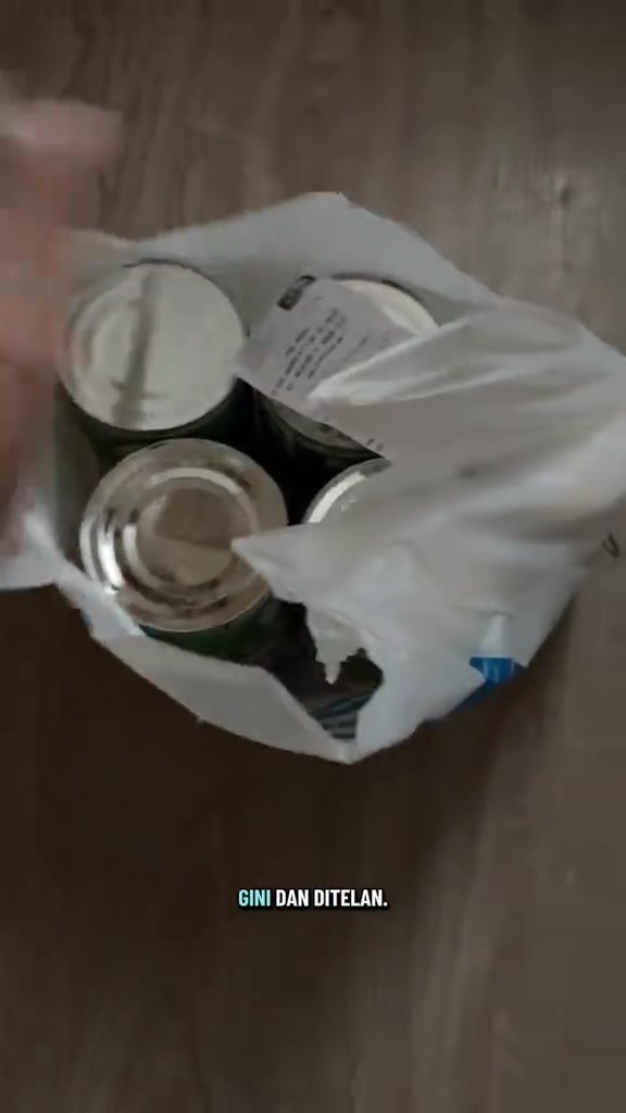 Beg plastik koyak akibat dikunyah kucing dengan tin makanan dan resit masih di dalamnya di atas lantai