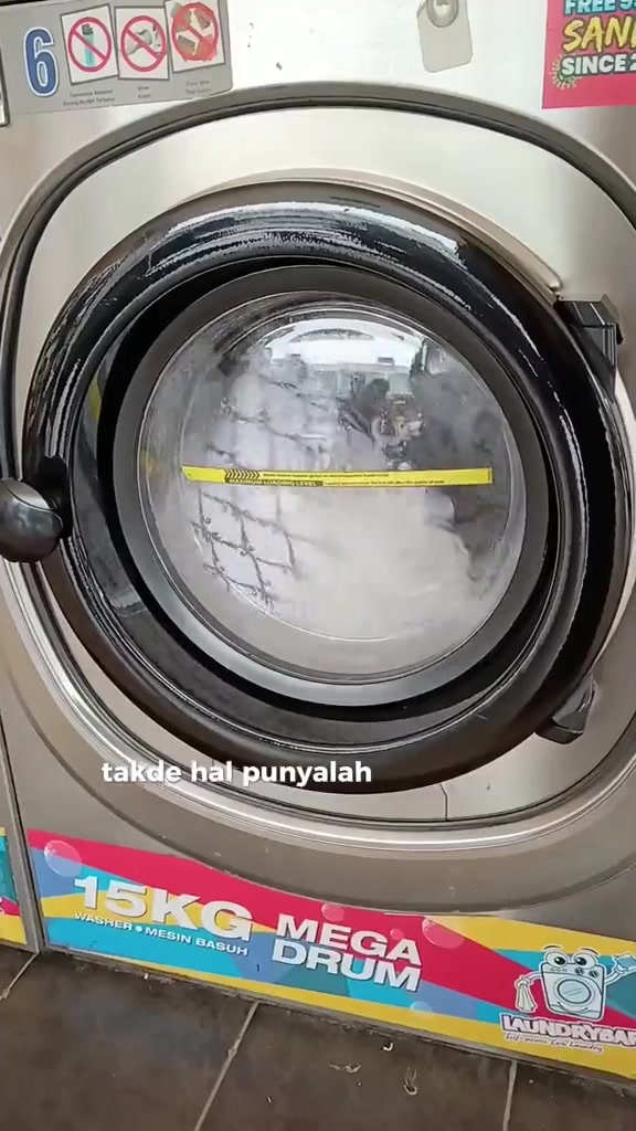 Bantal berpusing di dalam drum mesin basuh front load 15kg di dobi layan diri