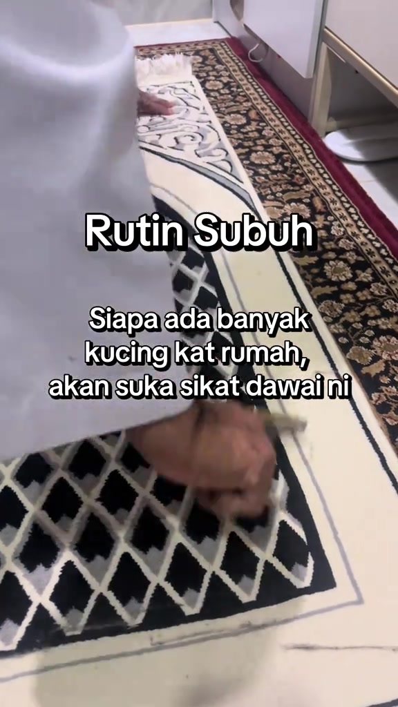 Tangan membersihkan bahagian kecil pada karpet bercorak hitam, putih dan merah