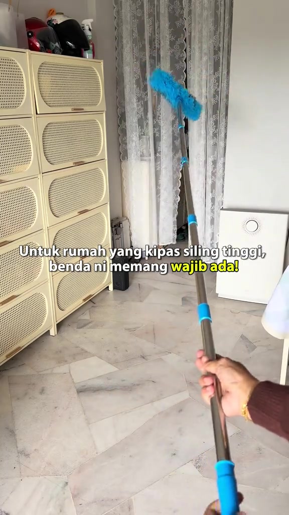 Batang duster panjang berkepala mikrofiber biru di dalam ruang rumah