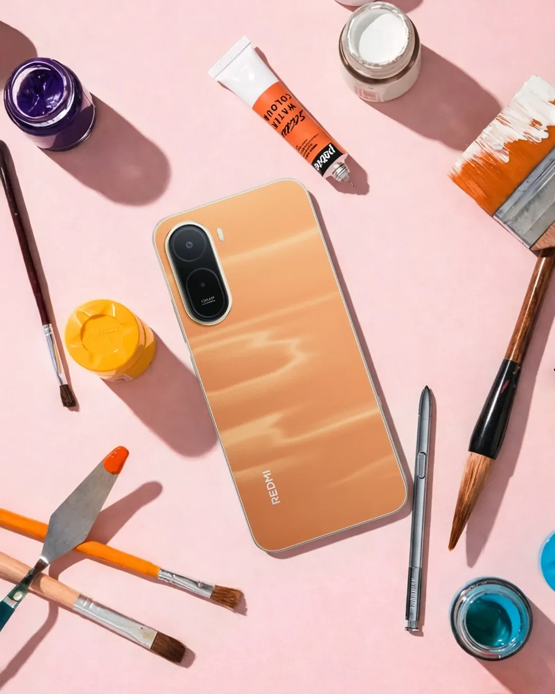 Bahagian belakang Redmi A7 Pro warna jingga diletakkan di atas meja kerja.