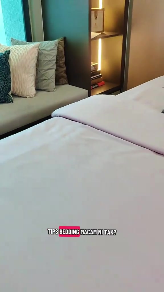 Katil dengan cadar putih kemas dan beberapa bantal tersusun