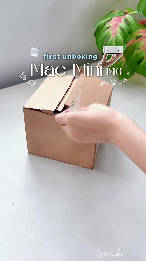 Tay mở hộp Mac mini M6 trên bàn trong lúc bóc hộp