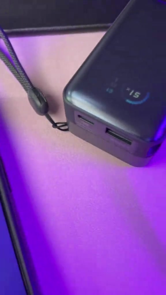 Pandangan dekat power bank Anker dengan kabel USB-C tersambung dan dua port pada sisi badan.
