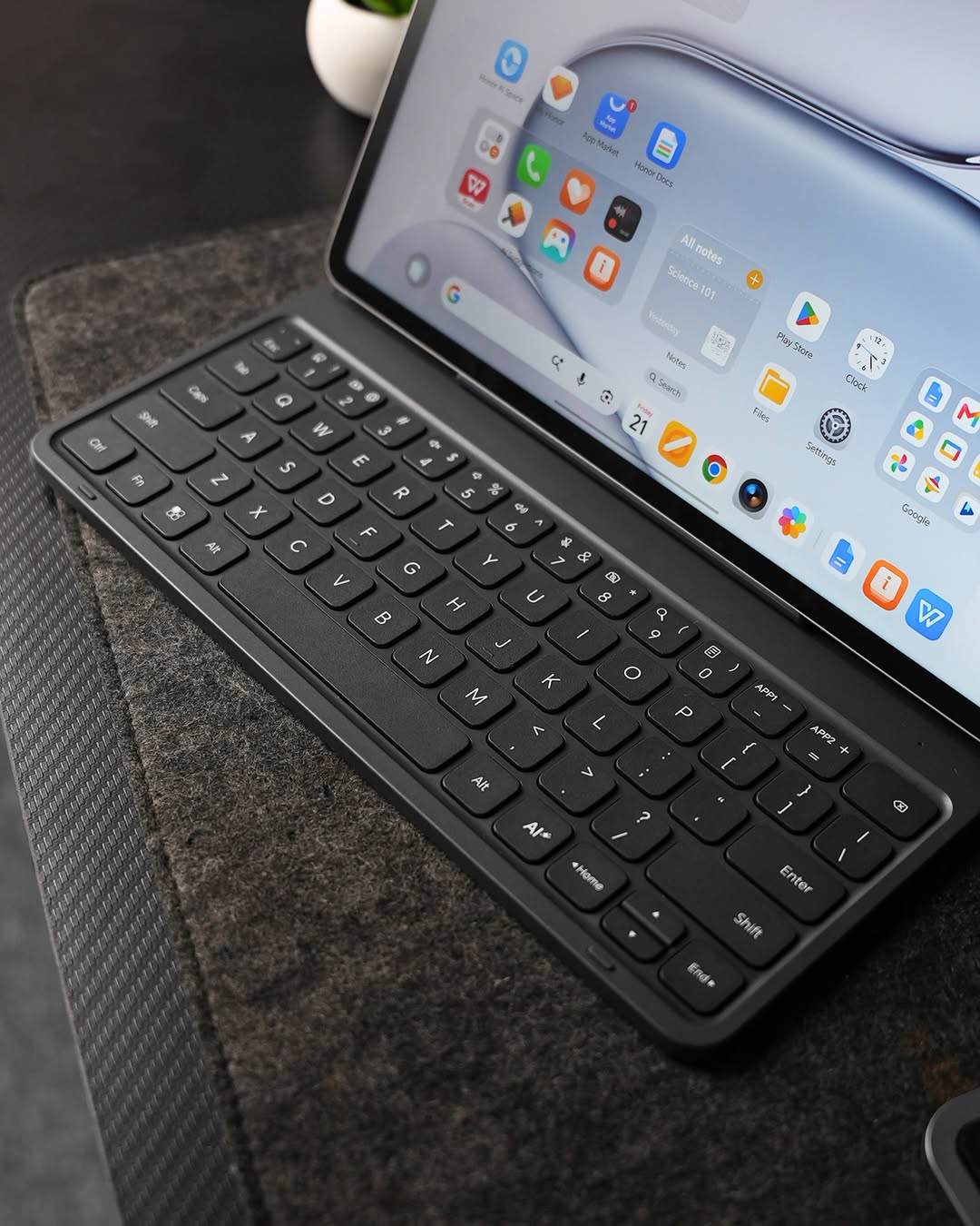Papan kekunci HONOR di hadapan sebahagian skrin tablet yang memaparkan ikon aplikasi.