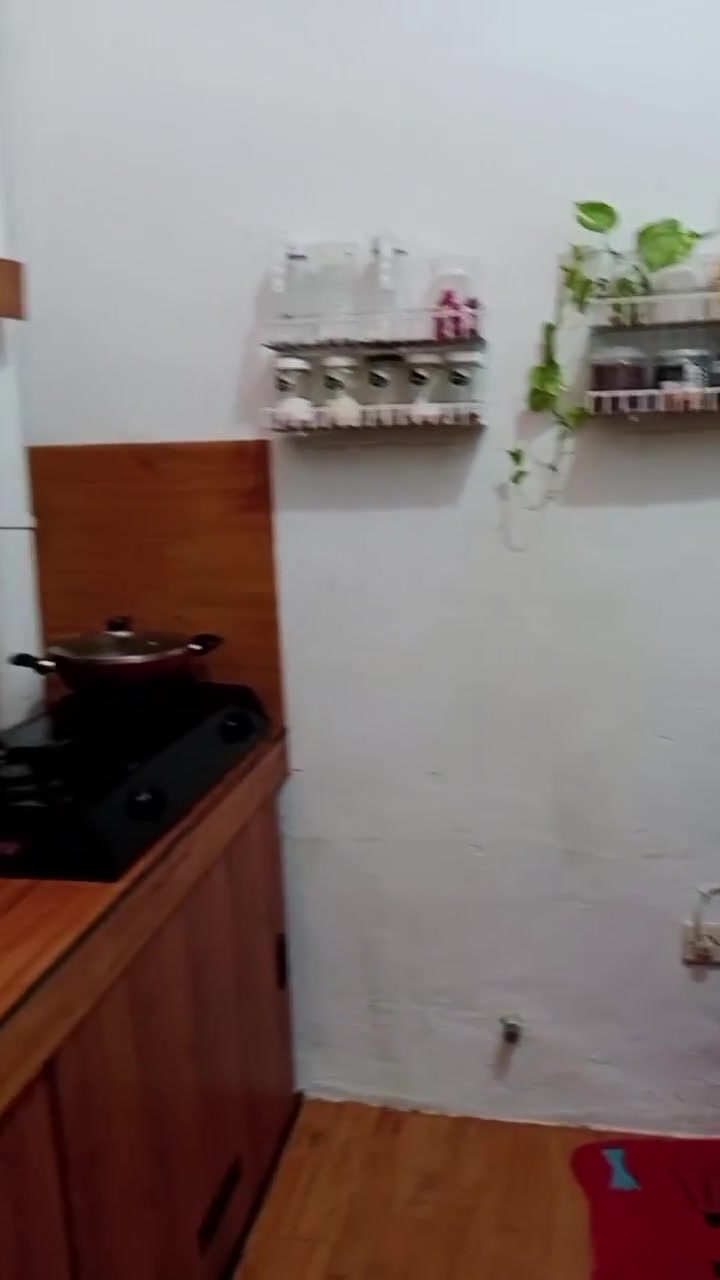 Dapur kecil dengan dapur masak hitam di sebelah kabinet dan kaunter