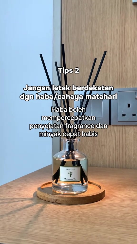 Botol reed diffuser di atas dulang bulat pada meja kayu