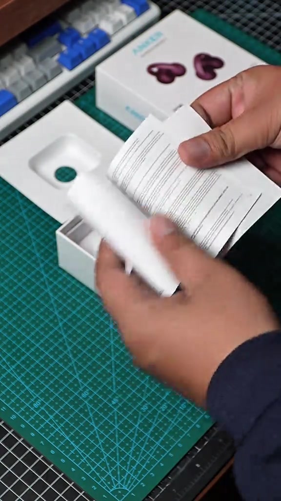 Tangan mengeluarkan kertas dan dulang pembungkusan AeroClip 2 daripada kotak