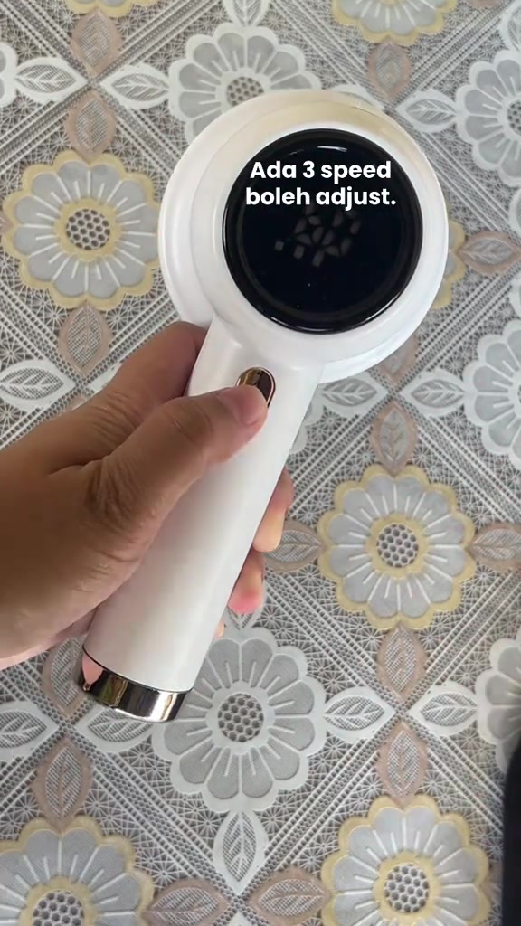 Tangan memegang fabric shaver putih dengan paparan kelajuan